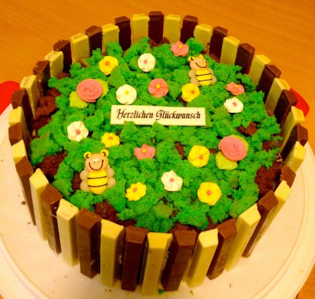 Blumengarten - Biskuitboden, Waldbeeren/Joghurtcreme, Biskuit eingefärbt und zerbröselt, Kit Kat Rand, Zuckerdekor